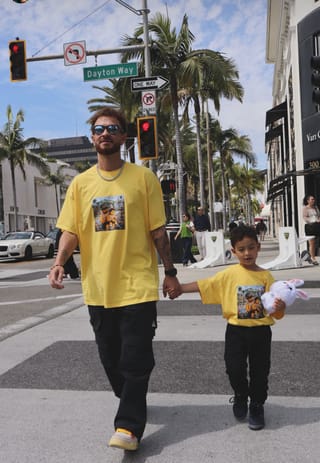 Pai e filho com camiseta Brasil atravessando a Rodeo Drive