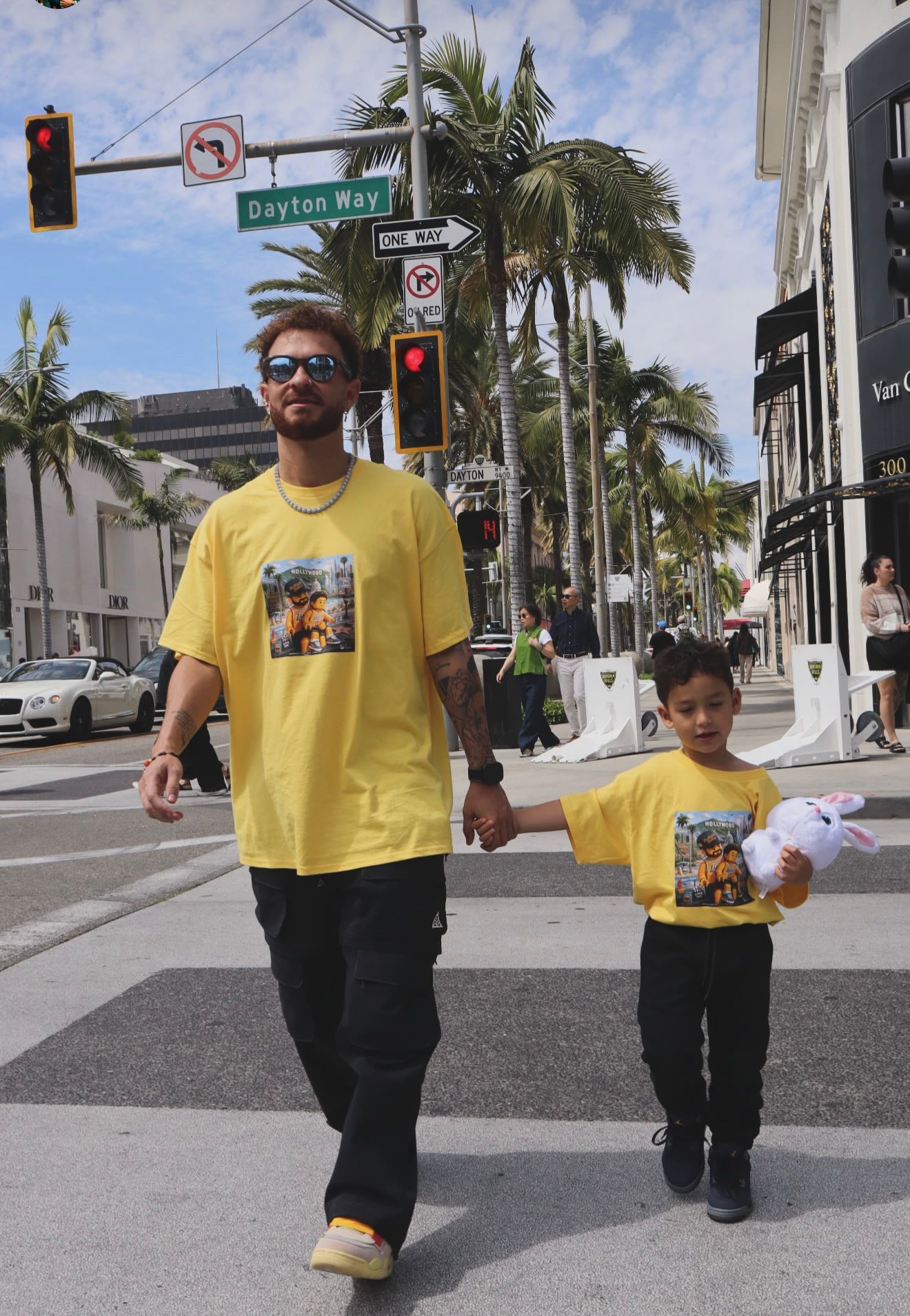 Pai e filho com camiseta Brasil atravessando a Rodeo Drive