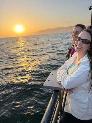 Amigas observando o pôr do sol no píer